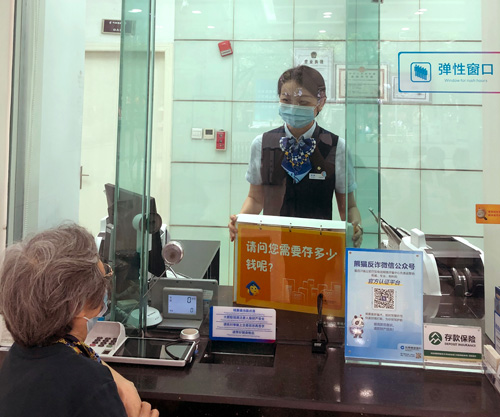 建行成都金河支行，柜面員工使用“關愛服務卡”服務老年客戶